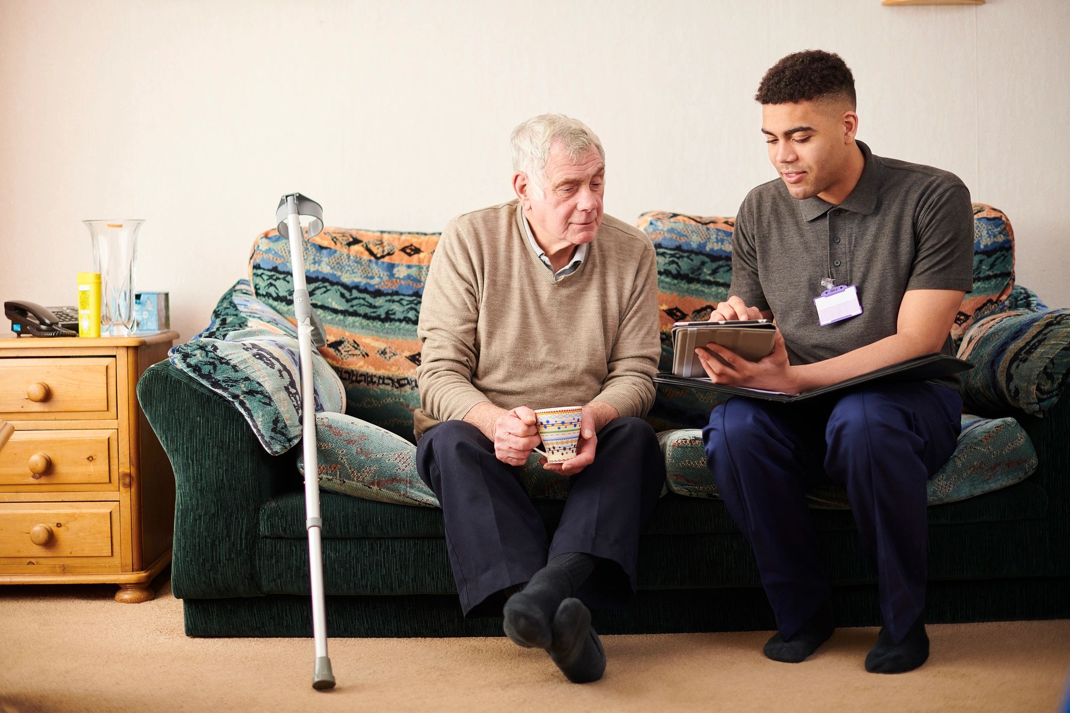 smiling support worker with elderly person in home care